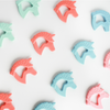 Flat lay with multiple colors unicorn teethers white background 