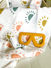 muslin swaddle blanket with suns and mustard yellow sunglasses teether