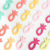 Flat lay of multiple pineapple teethers in multiple colors. White background. 