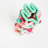 Cactus shaped teething toys stacked in multi colors. Top one is sage green 