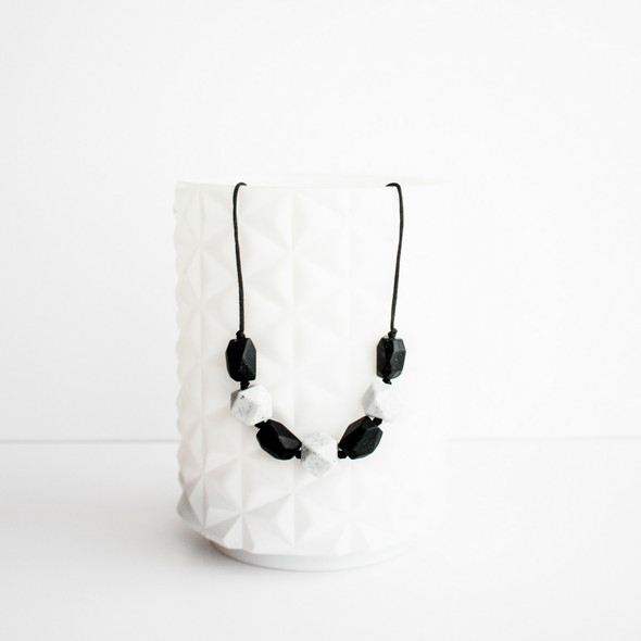 Harper teething necklace. White and black rock shaped silicone beads on a necklace. 
